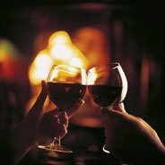 Two people touching wine glasses together